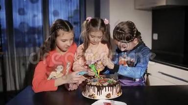 三个有趣的小女孩在<strong>蛋糕</strong>上画了一棵圣诞树和<strong>圣诞老人</strong>。 为父母提供<strong>蛋糕</strong>惊喜